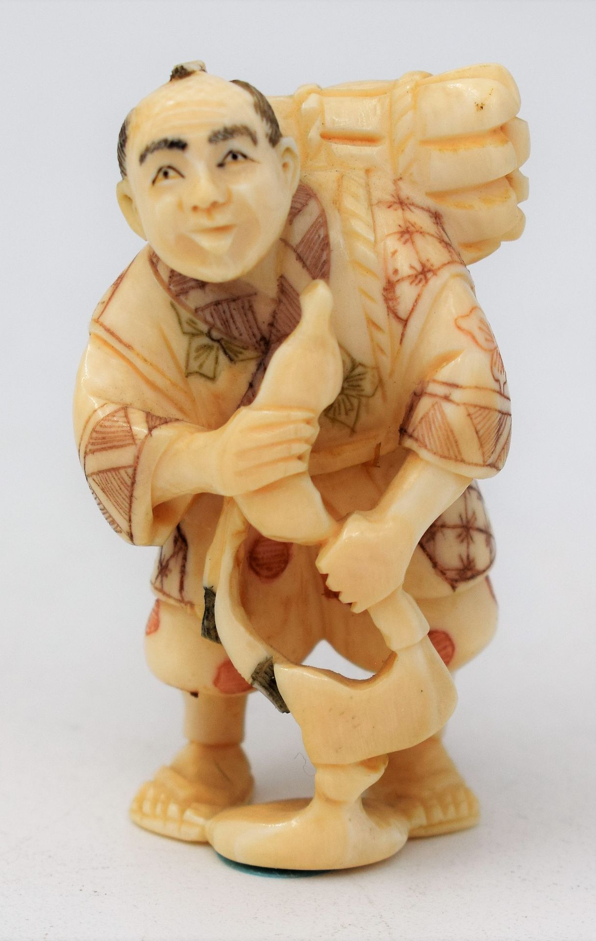 JAPON 
Netsuké en os représentant un homme portant un fagot de bois. 
XXème 
Hau&hellip;
