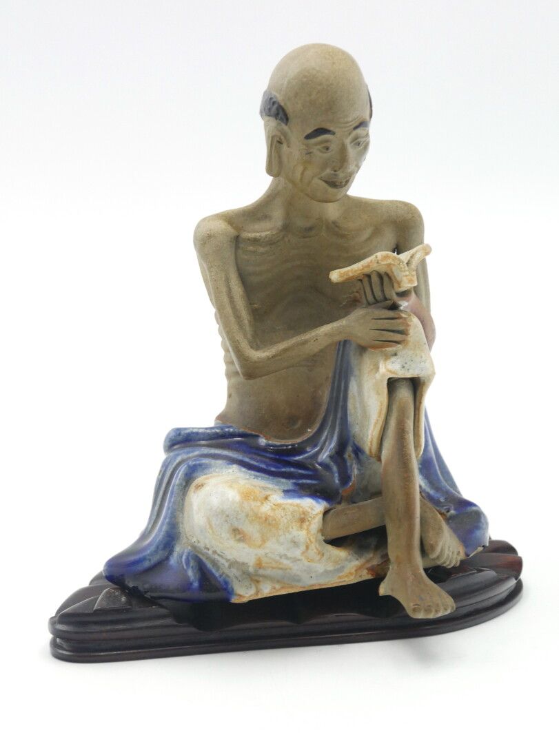 Null 亚洲

白色和蓝色珐琅彩陶器主题，显示一个坐着的学者

底座下的签名

木质底座

H. 主体：18厘米，7英寸。

腿部在两处恢复