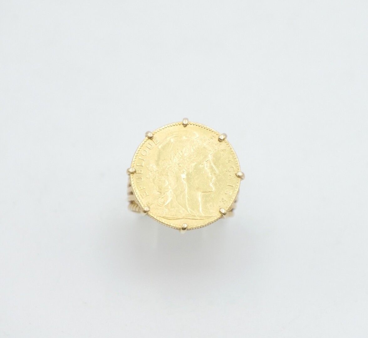 Null 法国 - 20世纪

镶嵌在戒指中的10法郎马里亚纳金币，镂空的黄金镶嵌750/1000e

总重量：9,4克。

手指大小：53

划痕，磨损状况