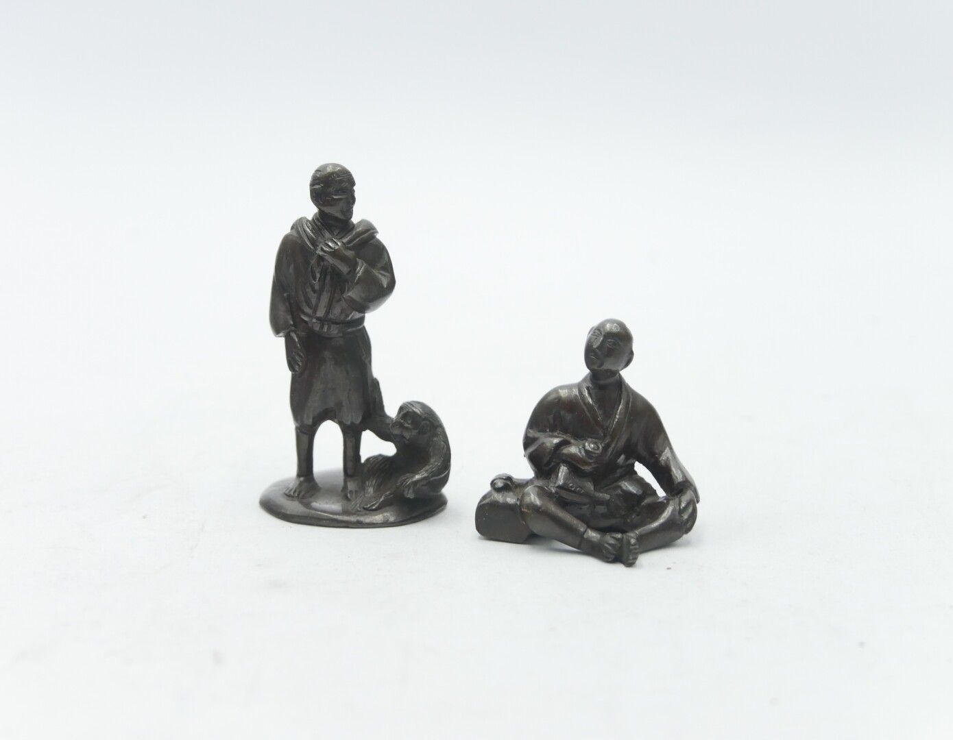 Null 亚洲 - 20世纪

两尊铜制铜像，一个人带着一只猴子，一个人坐着。

H.6,5和4厘米，2,5和1,5英寸。