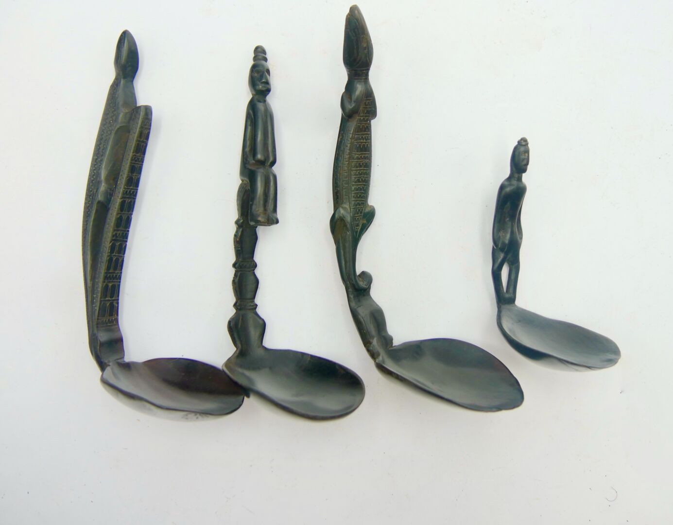 Null 一套四件亚洲类型的勺子

带有黑色铜锈的木材

长：9.5至16.5厘米。



雕刻着肖像的把手