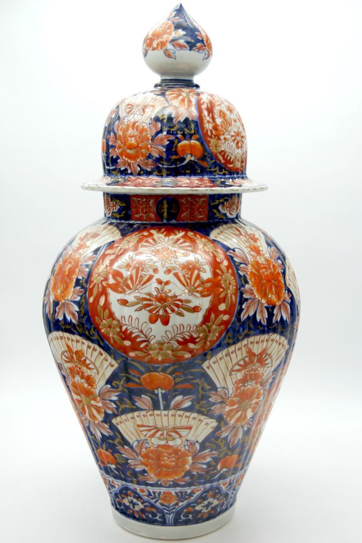日本，伊万里 - 20世纪 
釉下青花装饰的带肋巴洛克瓷瓶，用红色和金色绘有蝴蝶和花卷，扇子和牡丹，把手形成一个荷花蕾。 
总高度：63厘米，24 3/4英寸。&hellip;