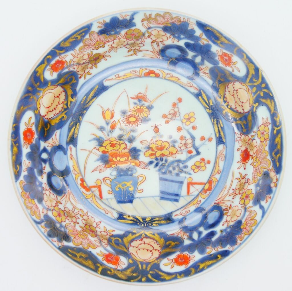 日本，伊万里 - 18世纪 
瓷盘，釉下蓝、铁红珐琅和金 "伊万里 "装饰菊花、牡丹和梅花的花瓶，翼上装饰同样的花和羊脂球 
直径：21.8厘米，8 1/2英寸&hellip;