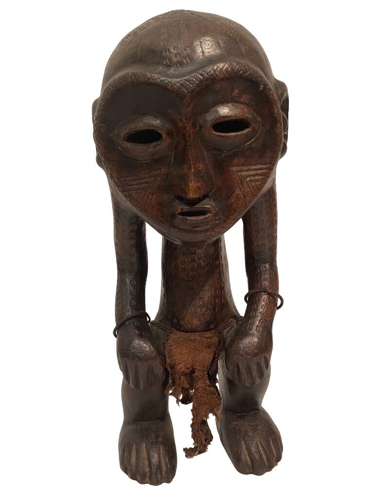 Null 刚果民主共和国 
Lega型雕塑
头部过大的人物，面部刻有心形。身体弯曲，双手放在膝盖上。
带有黑褐色铜锈的木头，织物，金属
H.46.5厘米。18.&hellip;