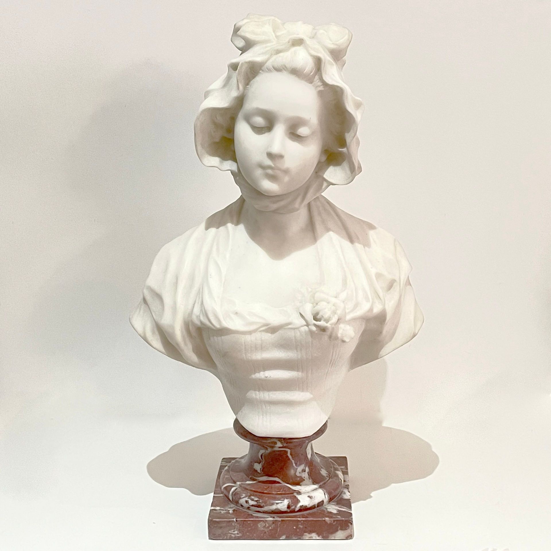 Null 古列尔莫-普吉（约 1850-1915 年） 
年轻女性半身像 
白色大理石雕刻，白色纹理红色大理石基座
背面有签名 
总高度：51 厘米 

底座有&hellip;
