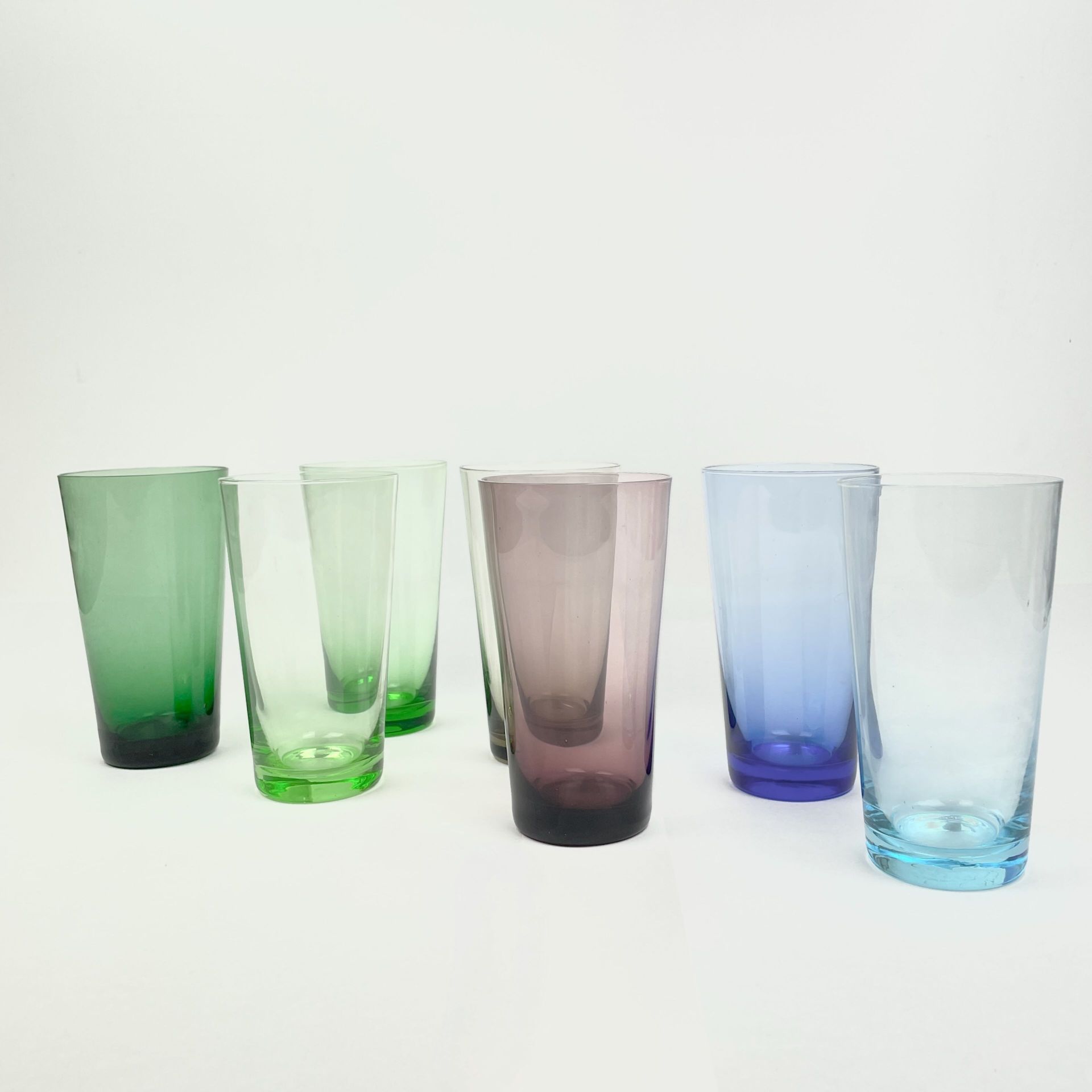 Null 约 1970 年 
7 件套蓝绿紫锥形玻璃杯 
H.13 厘米 

烧制缺陷（气泡），一只玻璃杯破裂，已使用过