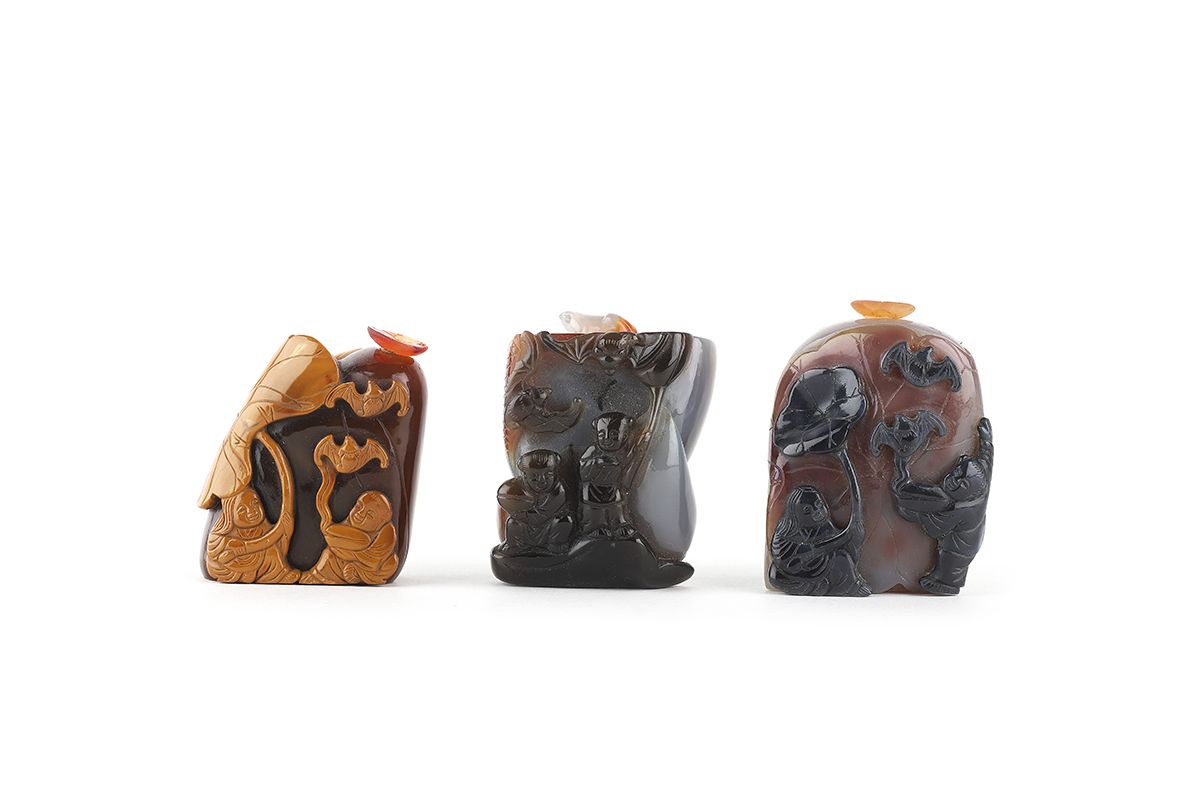 Null 中国，20世纪

一套三个浮雕玛瑙鼻烟壶，有人物装饰。从5.5厘米到7厘米高