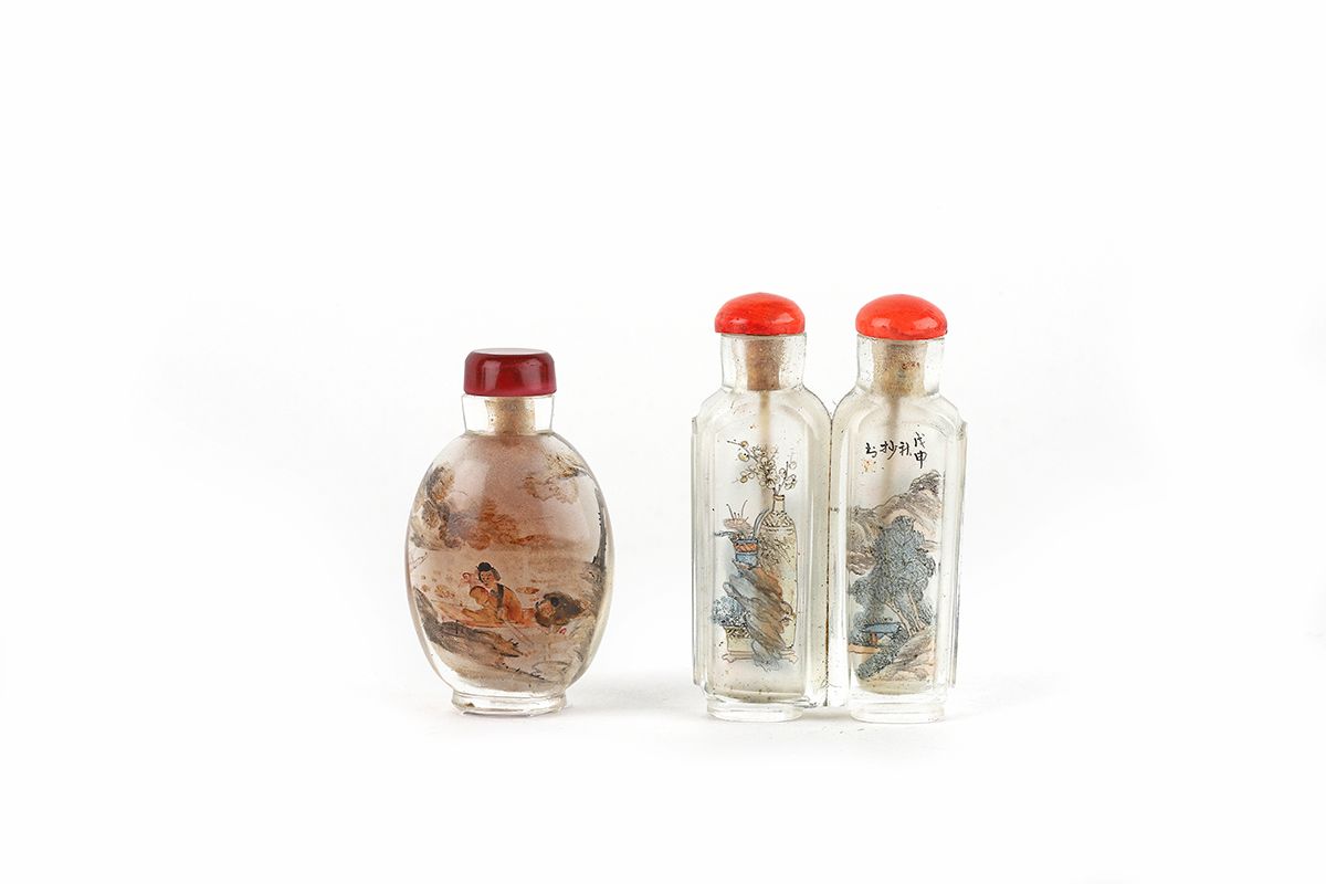 Null 中国，19世纪

一套两个内画的玻璃鼻烟壶，一个是蛋形的，上面有船的字符，红色玻璃塞。底部有裂缝。第二件是一个双鼻烟盒，装饰有风景、花枝和花瓶。珊瑚雕&hellip;