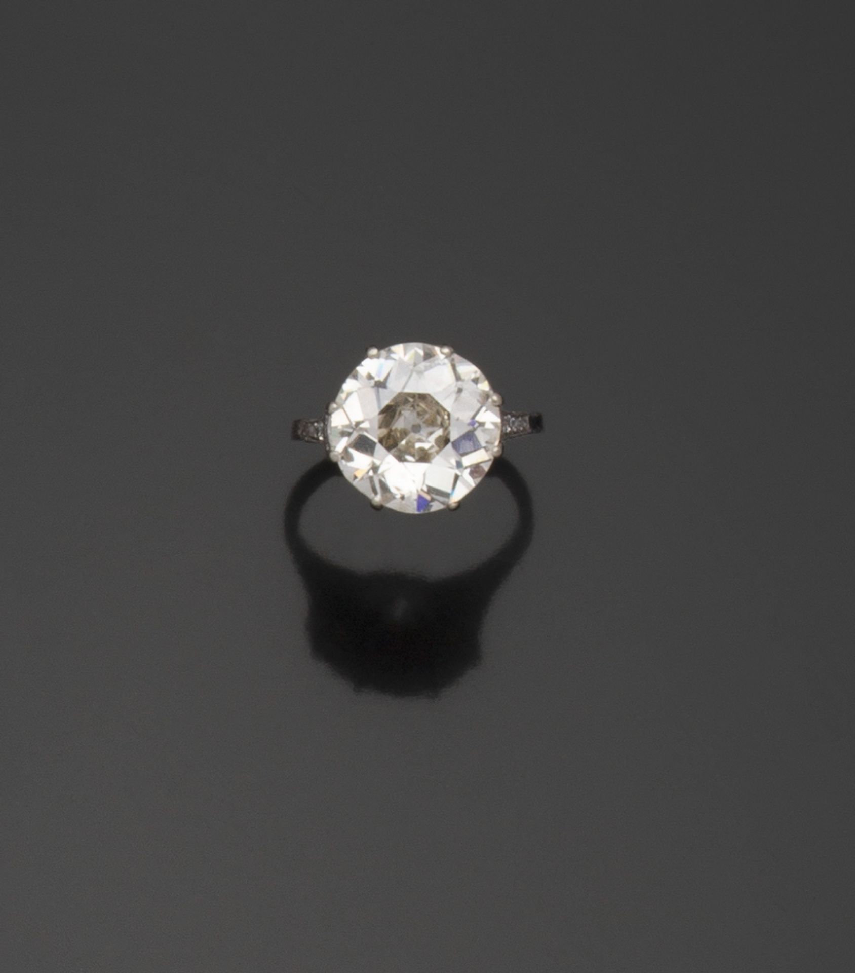 Null 铂金戒指（850/1000），以爪式镶嵌的老式欧洲切割钻石为中心，重达5.27克拉（已称重）。表圈上镶嵌着一排18颗玫瑰式切割的钻石，采用封闭式珍珠镶&hellip;