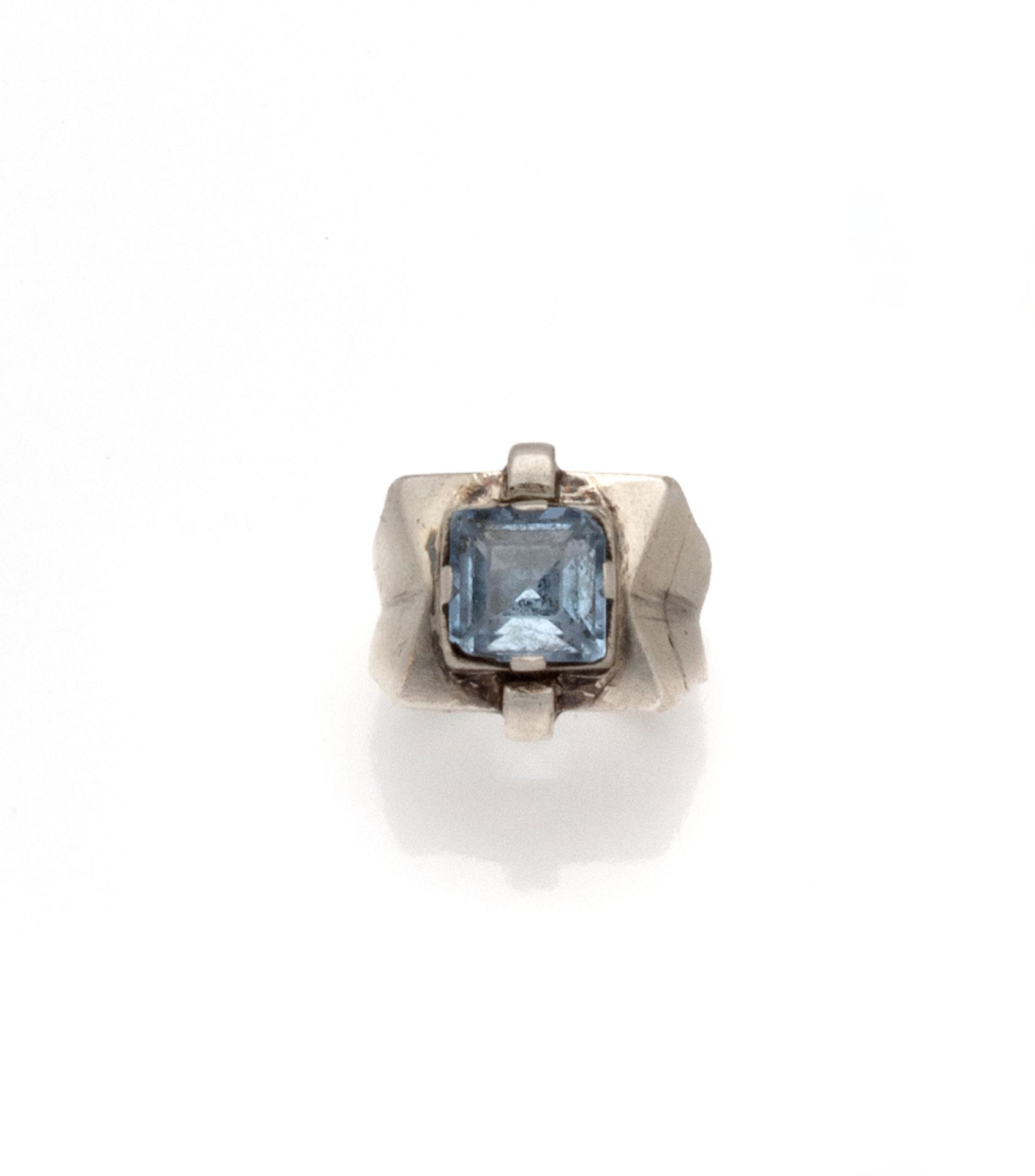 Null 
装饰艺术风格的银戒指（800/1000），中心是一颗封闭式的方形蓝宝石，肩部有两个小环。戒指被捏住形成一个雪佛龙。

法国作品，并有大师的标记痕迹。&hellip;