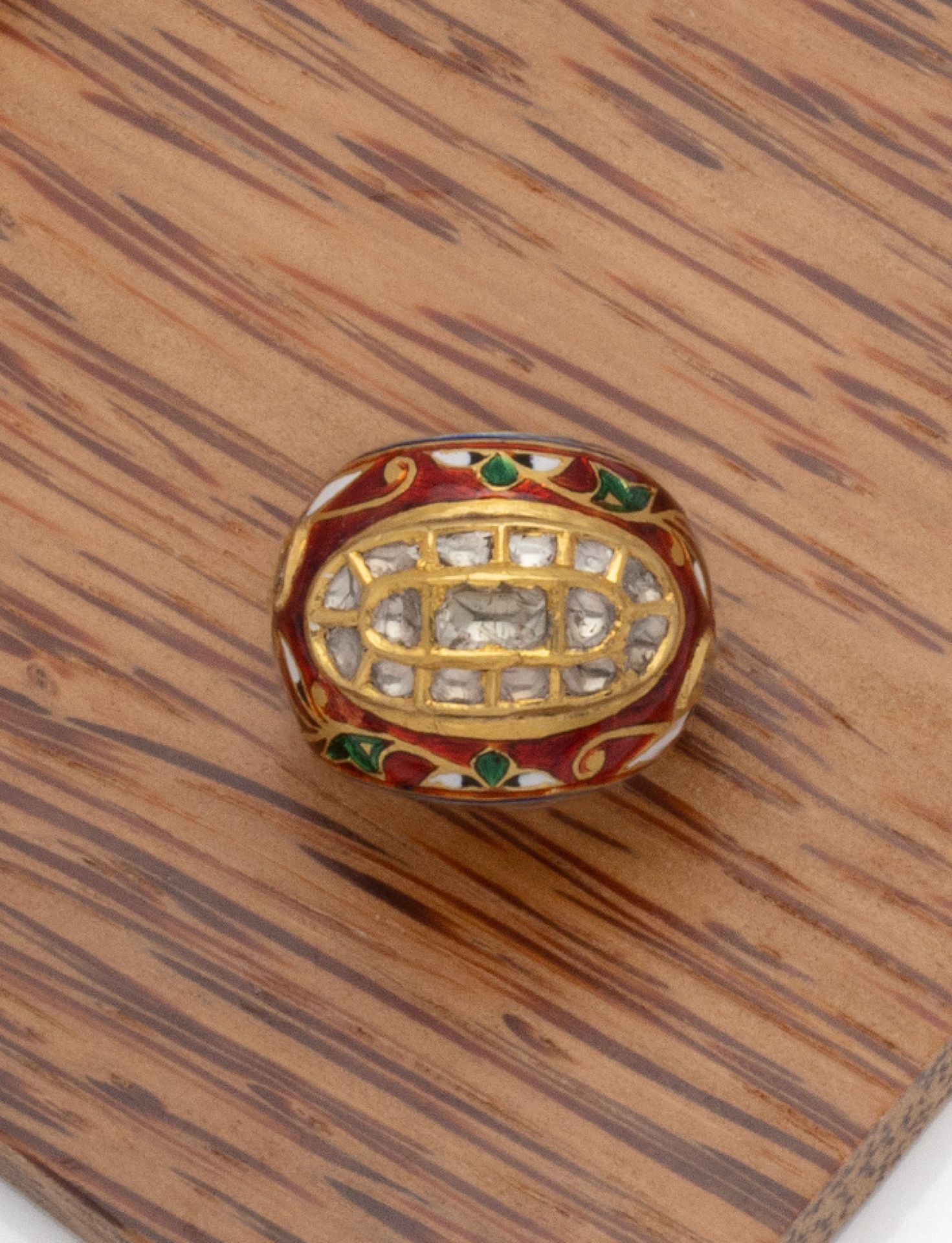 Null 一枚20K黄金戒指，主体装饰有多色珐琅的东方树叶，中心装饰有封闭式镶嵌的玫瑰式切割钻石的椭圆形图案。

印度作品，18世纪末/19世纪初

手指大小：&hellip;
