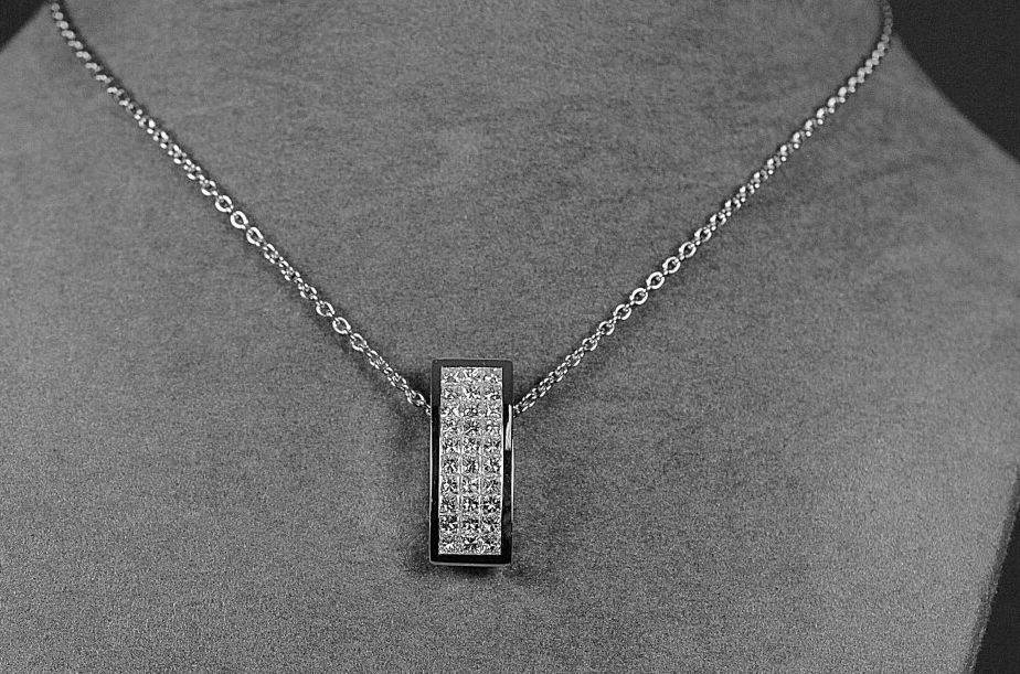 Null 现代形状的白金吊坠，镶嵌有30颗公主钻石，质量为G/VS，约1.50克拉，为隐形镶嵌。

重量：5,36克