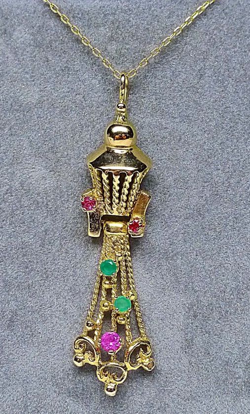 Null 黄金吊坠，镶嵌绿色和红色宝石

重量：4,30克