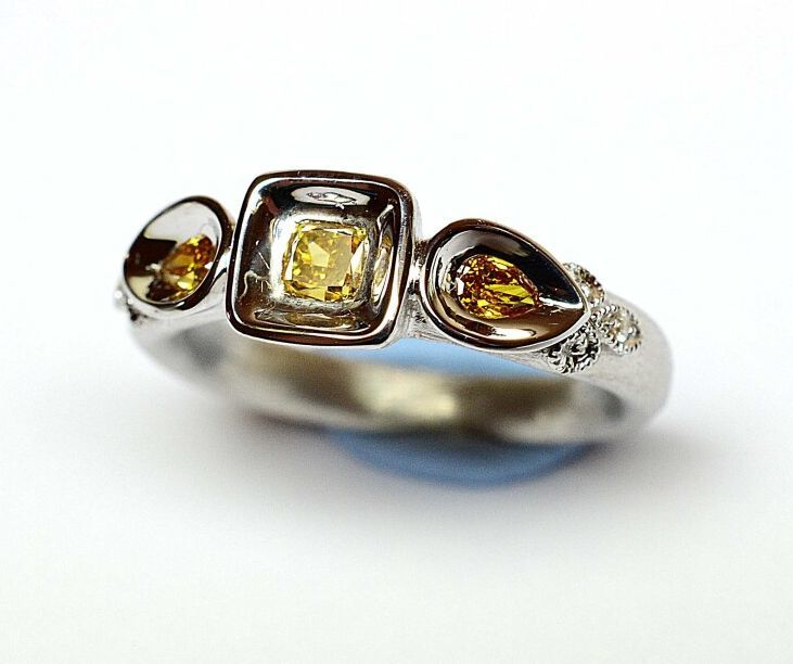 Null 拉丝白金戒指，镶嵌三颗枕形和梨形的NATURELLES颜色的钻石，约0.50克拉，加强白钻，约0.15克拉。

重量：6,84克