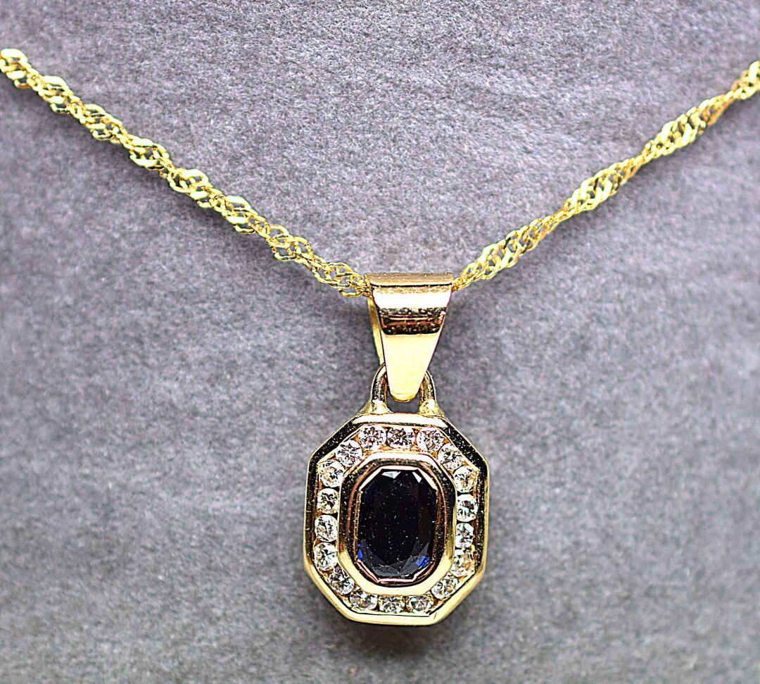 Null 黄金吊坠，以一颗1克拉的圆形切割蓝宝石为中心，镶嵌0.50克拉的优质圆形现代钻石。

重量：4,77克