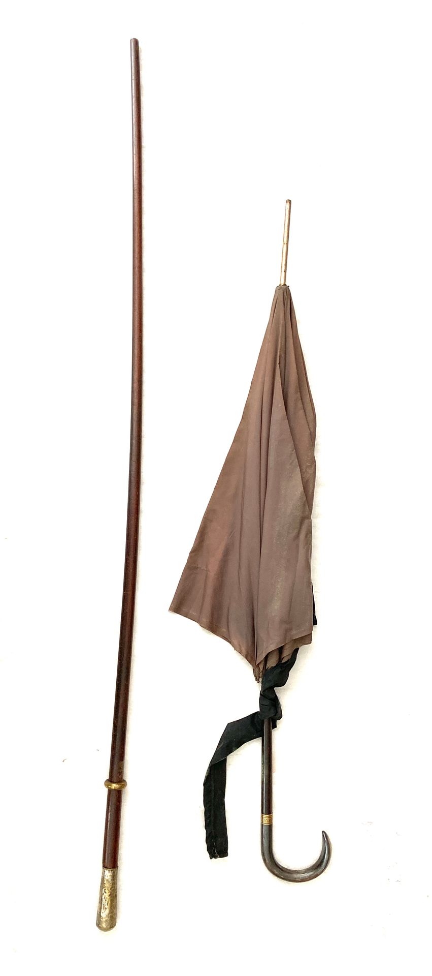 Null 一把阳伞，鞍座是镀金的金属大马士革。一根有镀银把手的手杖，上面装饰着压花的叶子，有字。损坏的。