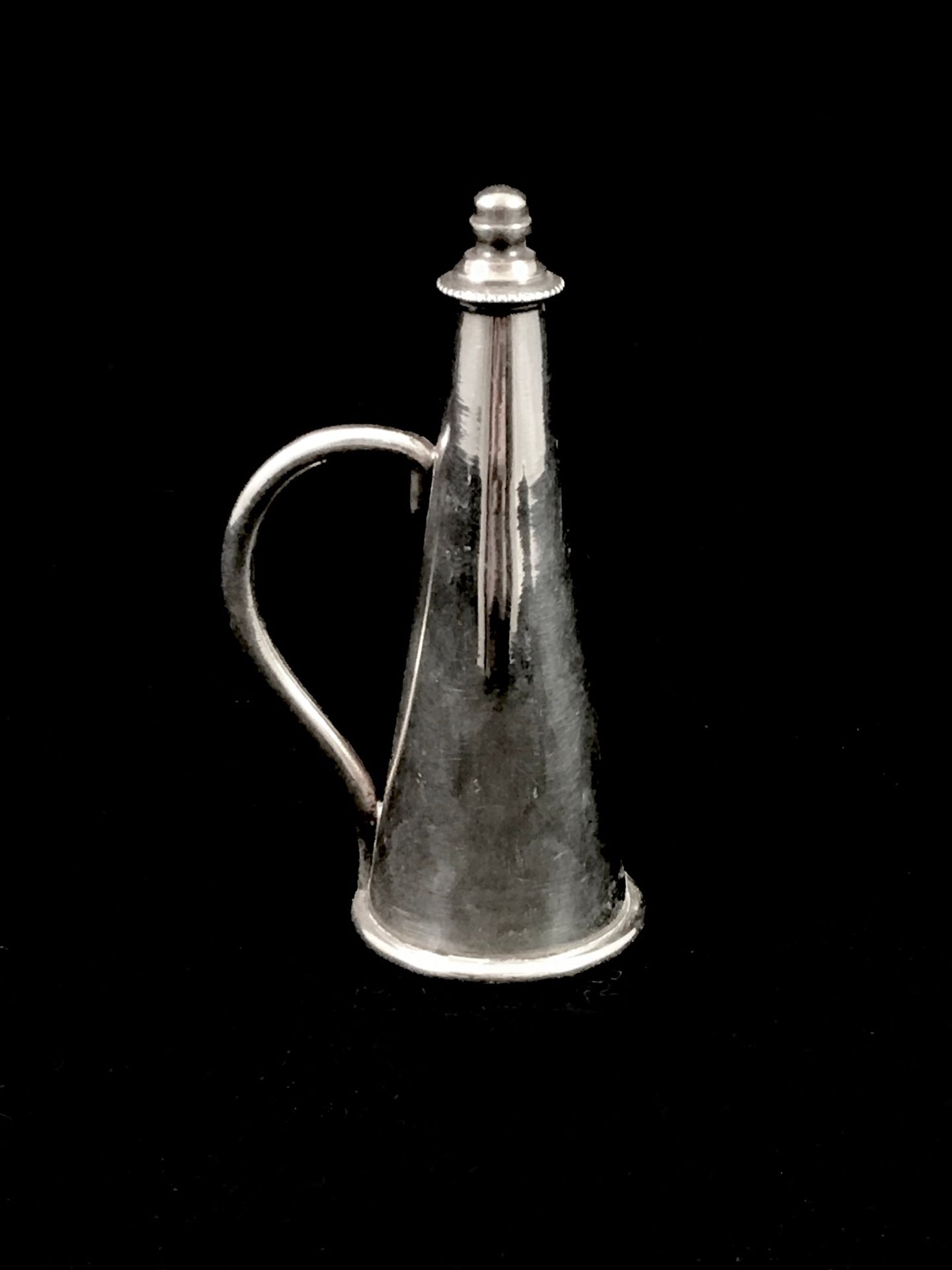 Null Un etouffoir en métal argenté de forme conique. Haut. 8,5 cm.