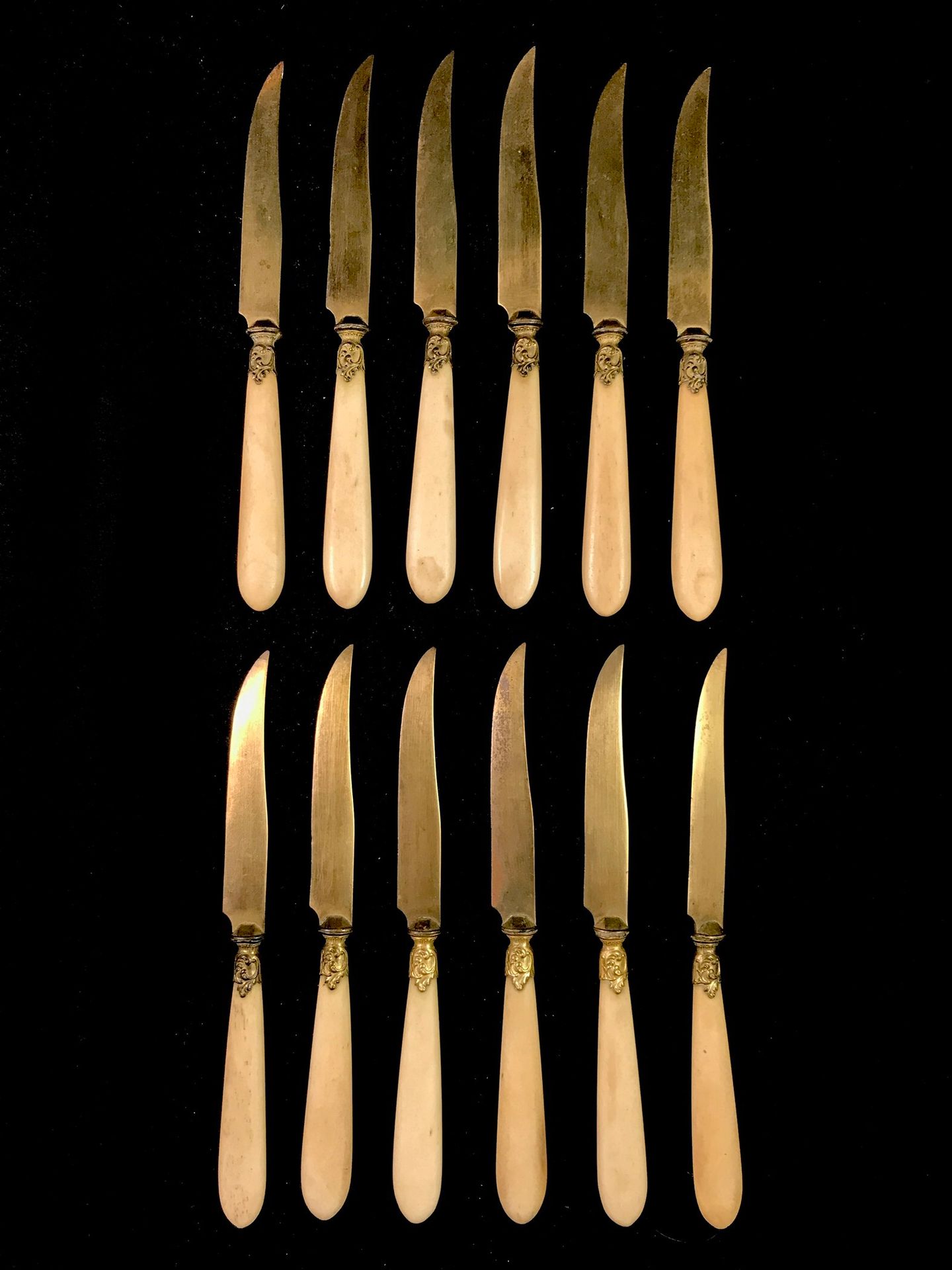 Null 
一套12把的甜品刀，骨质手柄。刀片和套圈为镀金金属。新路易十五风格。