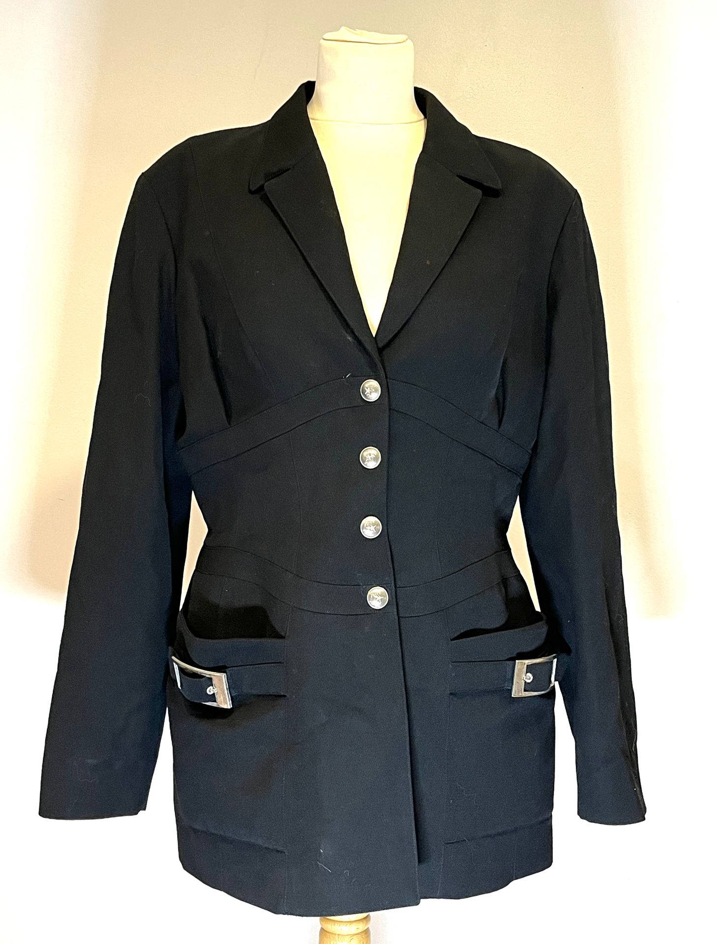 Null 蒂埃里-穆格莱。黑色羊毛长外套，腰线上的镶嵌细节形成了一个类似胸衣的形状，正面由银色扣子封闭。前面有两个贴袋，并配有皮带环。
