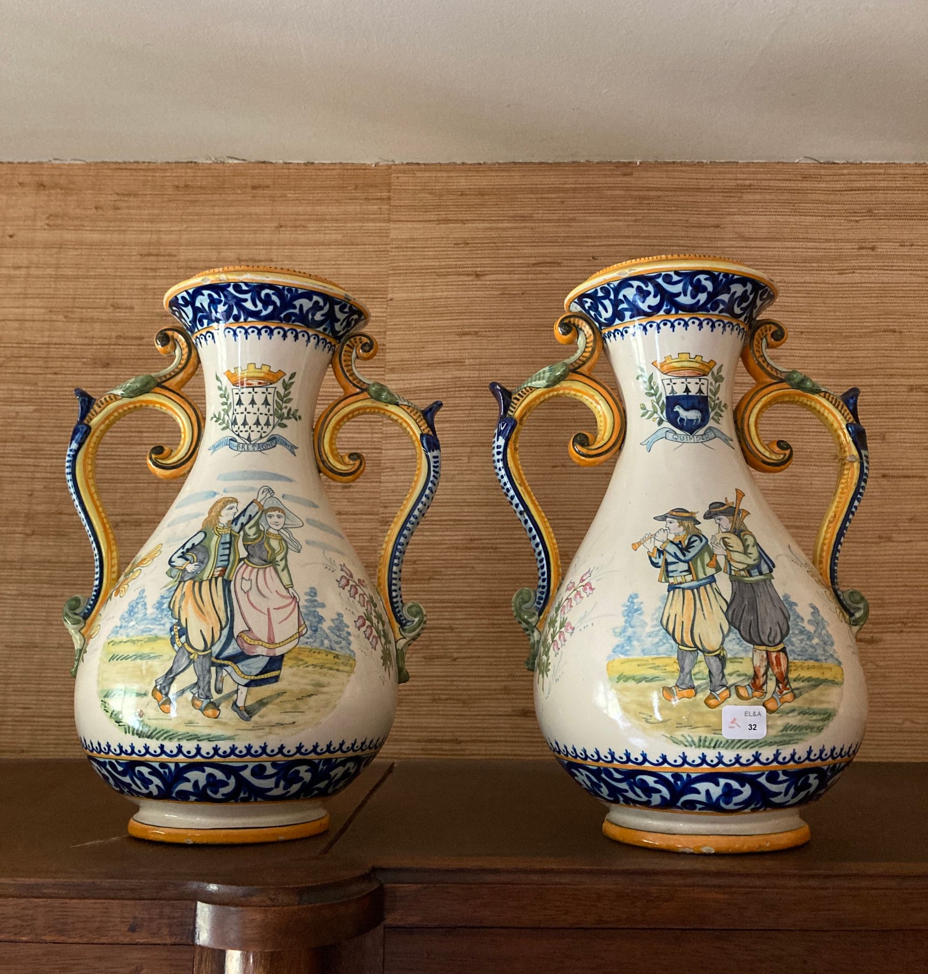 Null 
QUIMPER HENRIOT - 一对带把手的陶器海盗形花瓶，装饰有跳舞的布列塔尼和纹章装饰 高度：34厘米。