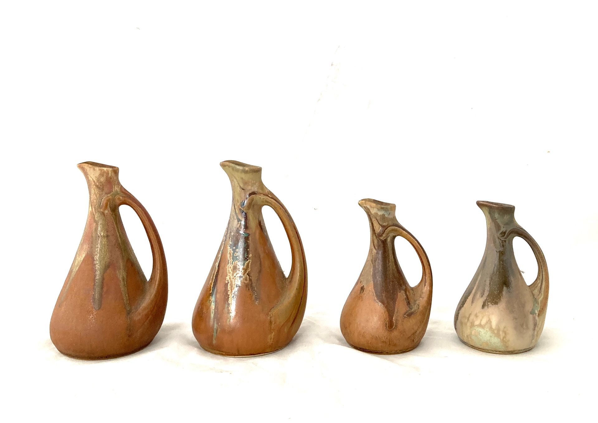 DENBAC 
Suite of four small jugs in enamelled stoneware. 
Signed on the back. 
A&hellip;