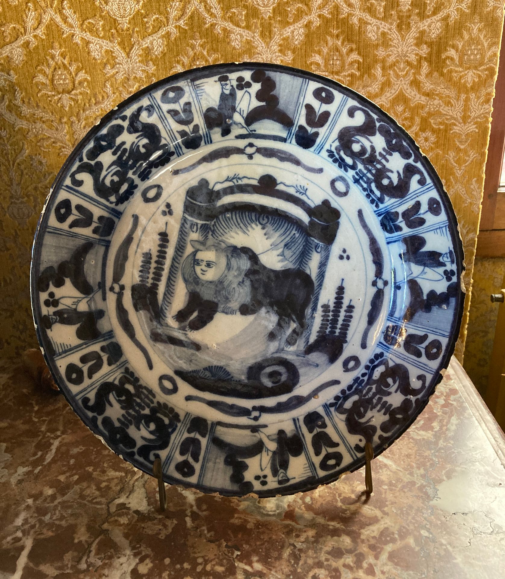Null 
34.代尔夫特 




圆形陶器盘，饰有狮子和两根柱子 




直径：31厘米




18世纪。




嘴唇上的伤痕和事故。