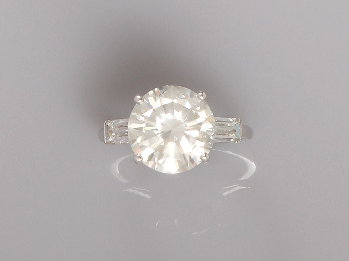 Null 白金单颗钻石戒指，在两颗长方形钻石之间镶嵌了一颗重约5.30克拉的明亮式切割钻石，推定为H色，SI1品质，直径约7毫米，尺寸：54，重量：6.2克毛重&hellip;