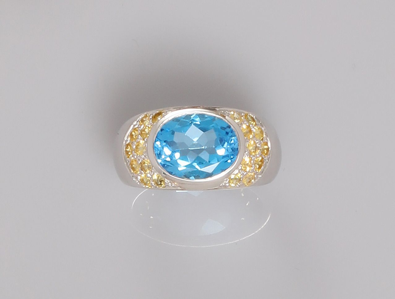 Null 白金戒指，750毫米，以一颗重4.20克拉的蓝色黄宝石为中心，夹在两颗密镶的黄色蓝宝石之间，尺寸：52，重量：毛重8.5克。