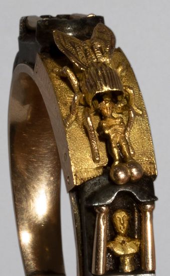 Null 罕见的、漂亮的金和钢的诱惑性忠贞戒指，有系统。

钢环上有小孔，中心是一只金蜜蜂，两边是两个

两个带独立柱子的壁龛，里面有两个罗马皇帝的半身像

(&hellip;