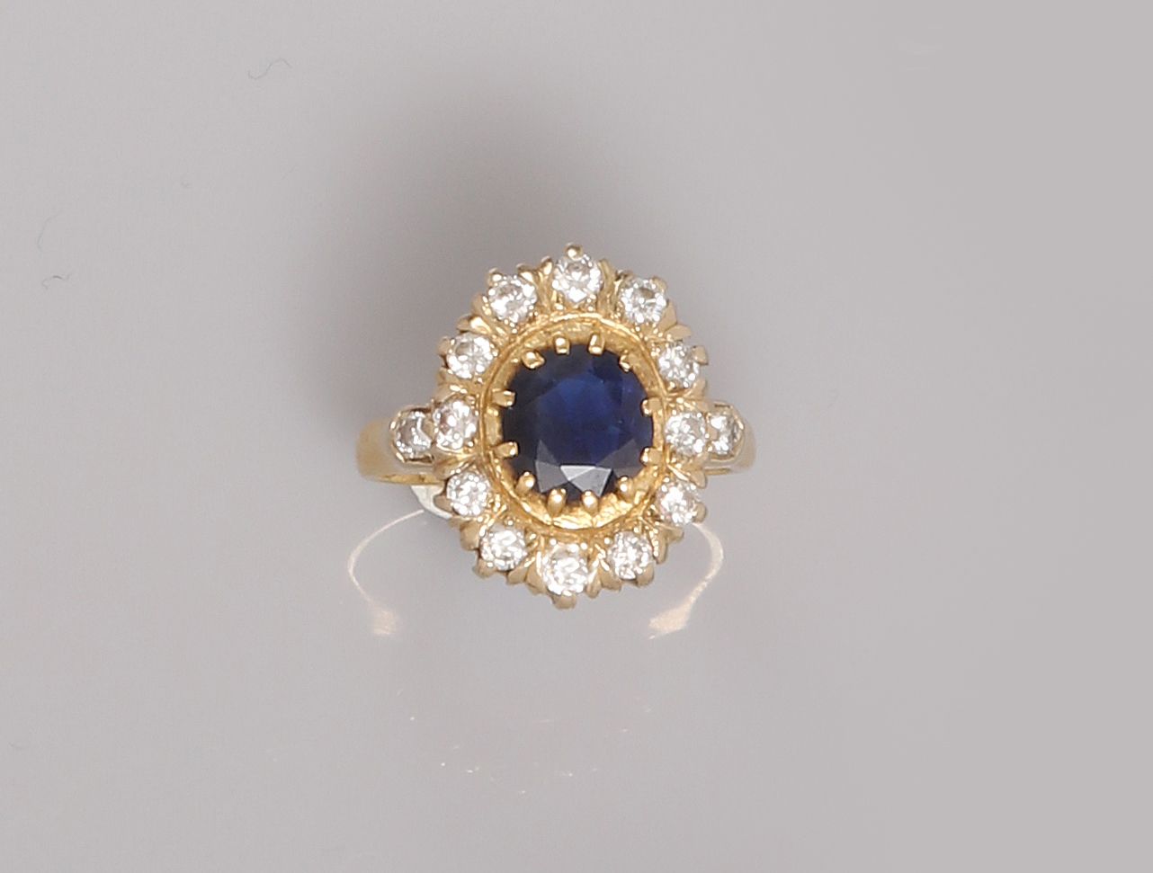 Null 黄金戒指，750毫米，以一颗椭圆形蓝宝石为中心，在两颗钻石之间有一排钻石，共约1克拉，尺寸：49/50，重量：5.7克，毛重。