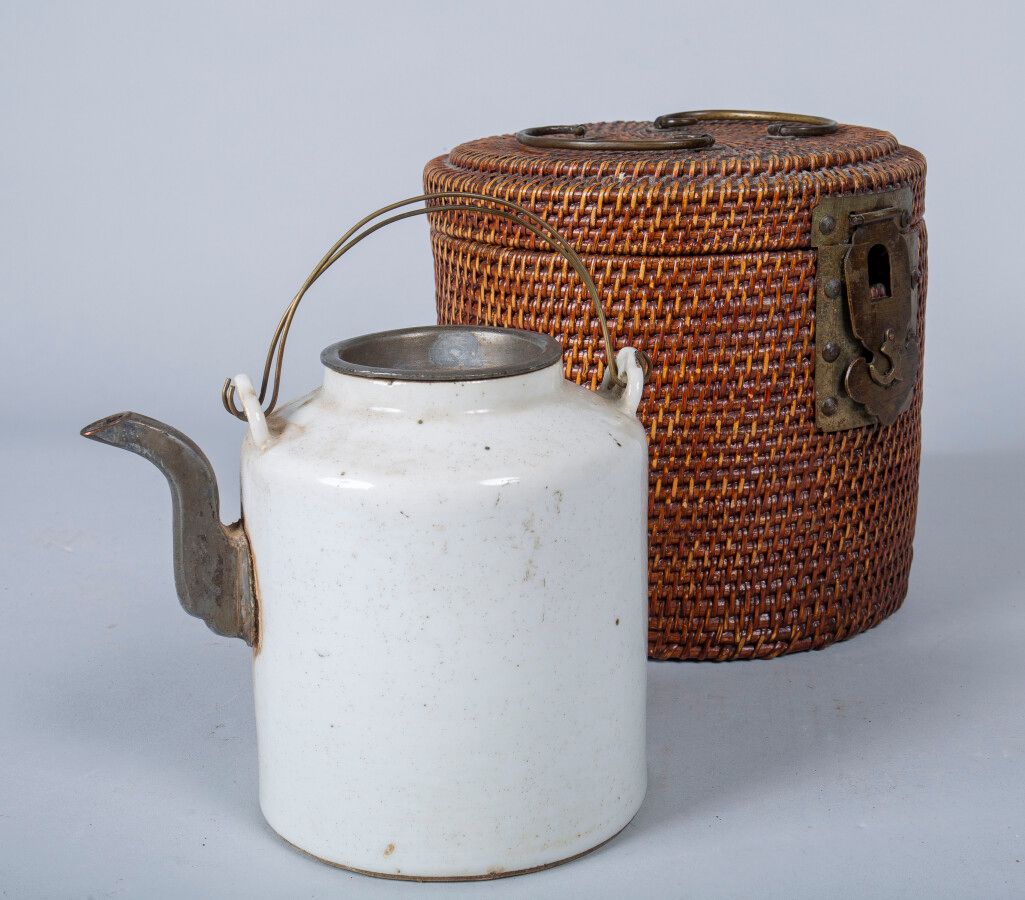 Null 中国，19世纪末，一个圆柱形的瓷质茶壶，上面有奶油色的釉，壶嘴和盖子是锡制的。在它的柳条筐里。(壶嘴下面有裂缝）。)高14厘米。专家 : ANSAS &hellip;