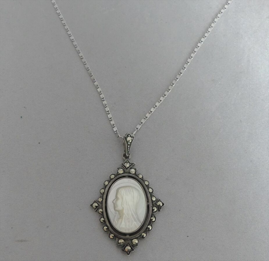 Null 银质拍品，由一条蜗牛链和一个椭圆形奖牌组成，白色珍珠母，代表一个圣母，在玛瑙框架中。毛重10,72克 - 链长49厘米 - 勋章高度5厘米。专家：Bé&hellip;