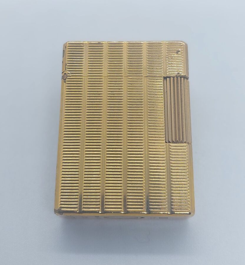 Null DUPONT - BRIQUET en métal plaqué or, à décor de cannelure, petit modèle.
