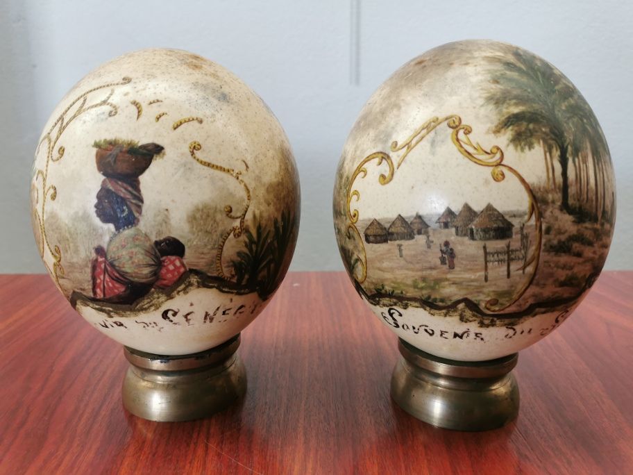 Null 
一对带有非洲装饰的鸵鸟蛋，每个都放在一个圆形的铜质底座上