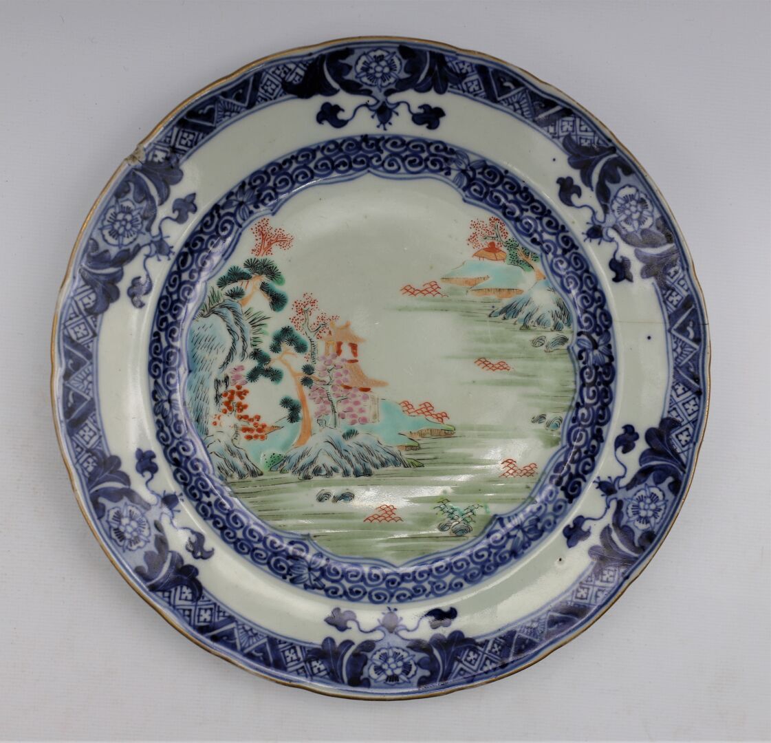 Null 一个法米勒玫瑰瓷器和多色珐琅盘，中央饰有湖泊景观的徽章，蓝白色的边缘饰有螺旋和植物的图案。中国，19世纪。

直径：21.8厘米。(裂痕和裂缝）。
