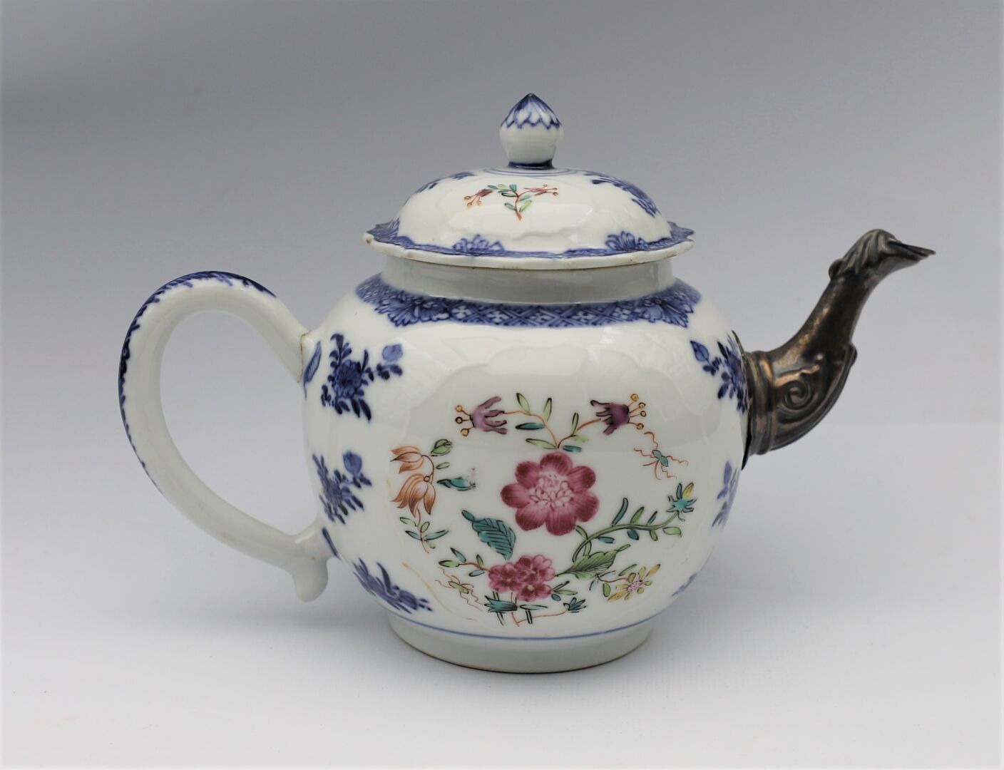 Null 一个漂亮的Famille Rose瓷器和多色珐琅茶壶，带有花卉装饰，银质壶嘴。中国，19世纪。

高度：13厘米。(手柄上有裂缝）。