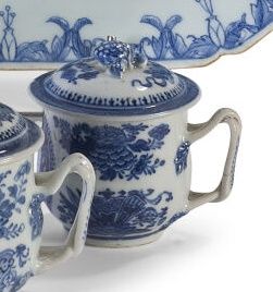 Null 一件白色和蓝色的珐琅彩瓷器盖杯，上面装饰着家具、卷轴和花朵。中国，19世纪初。

高度：8厘米。(裂痕和裂缝）。