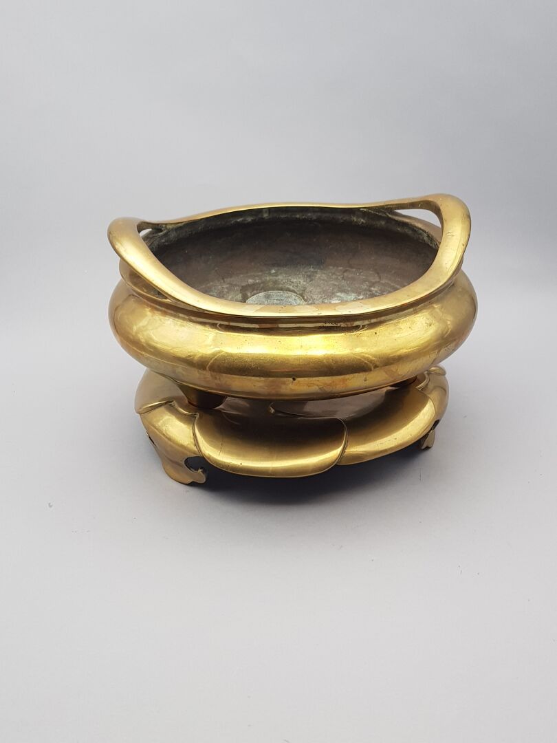 Null 鎏金青铜大鼎香炉，圆形，有两个把手。底座下有一个谚语的重要标记。在其底座上有一朵造型优美的莲花。

印度支那，20世纪初。

直径：31.5厘米。