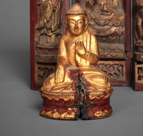 Null 雕刻和镀金的小木佛。坐在双层莲花状底座上的帕德玛萨那。

印度支那，19世纪末和20世纪初。

高度：13.5厘米。

(裂缝)。