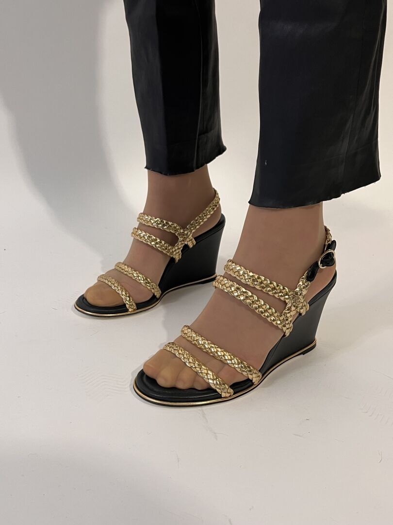 Null 香奈儿

一双黑色皮质平台凉鞋。编织和金色的带子。

尺寸：39

鞋跟高度：10厘米