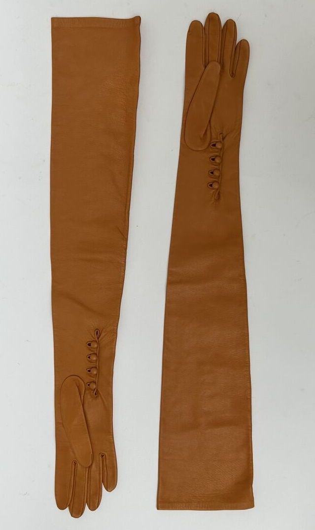 Null 克里斯蒂安-迪奥

一对长的金色小羊皮手套。前臂上有四个皮扣。

总长度：67厘米。最大宽度：13厘米。