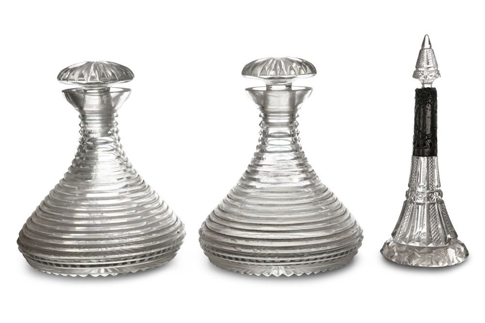 Null 一对19世纪的切割玻璃船用蒸馏器，有阶梯状的凹槽装饰，有凹槽的瓶塞；还有一个维多利亚时代的切割玻璃和银制的香薰瓶（3）。醒酒器高22厘米