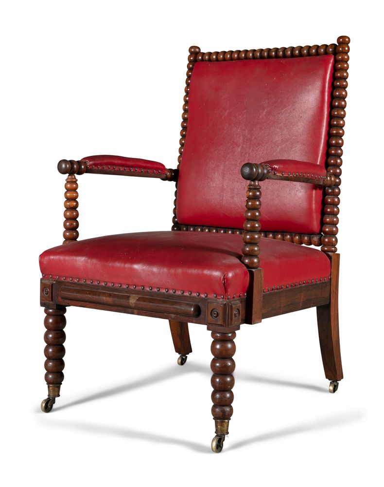 Null 一把爱尔兰19世纪的纺锤形胡桃木扶手椅，按照斯特拉汉的方式，用红色的皮革做软垫，放在细长的纺锤形腿上，带有脚轮。深66厘米 x 宽69厘米 x 高10&hellip;