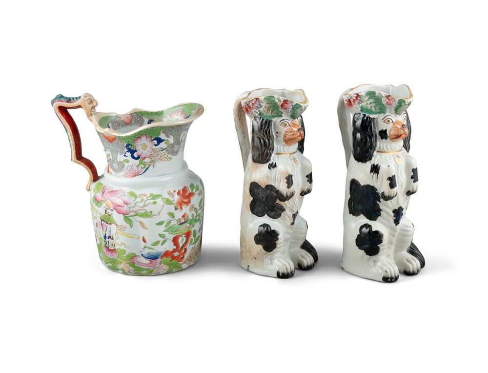 Null A PAIR OF 19TH CENTURY STAFFORDSHIRE JUGS, moulded in the form of spaniels.&hellip;