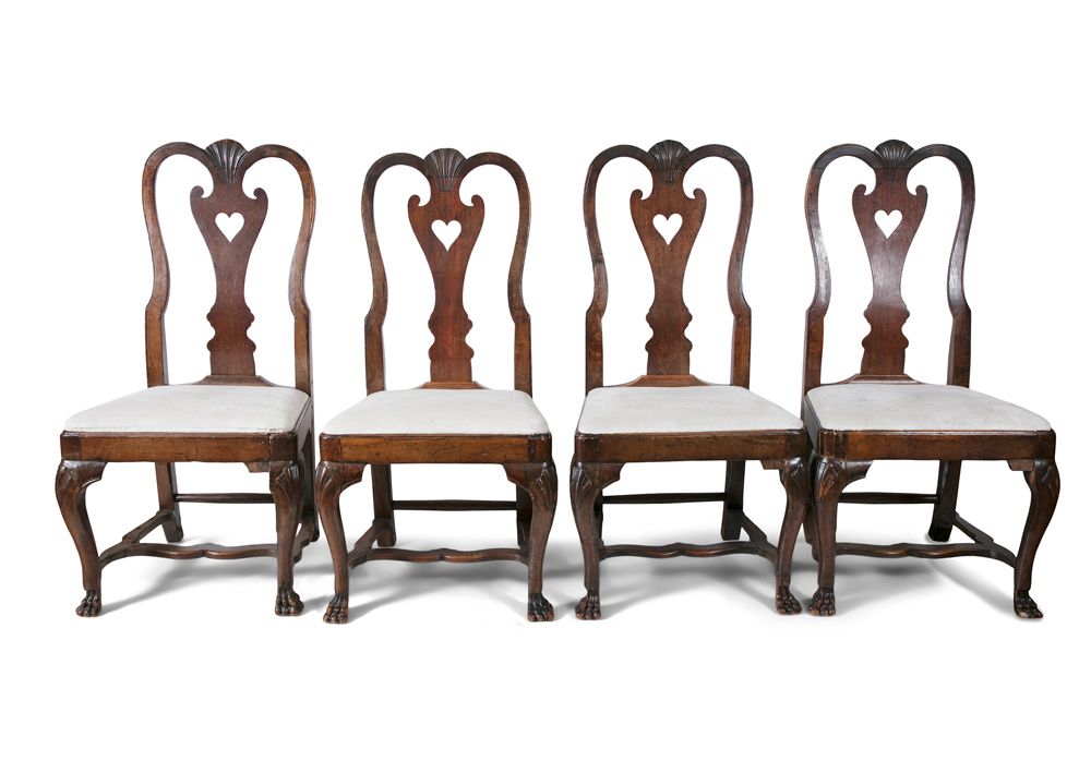 Null 乔治二世时期的四把橡木餐椅，每把椅子都有贝壳雕刻的顶栏，上面有花瓶形的夹板和软垫的落座，用扇形的小腿和爪子支撑，用H形的担架连接，高103厘米。