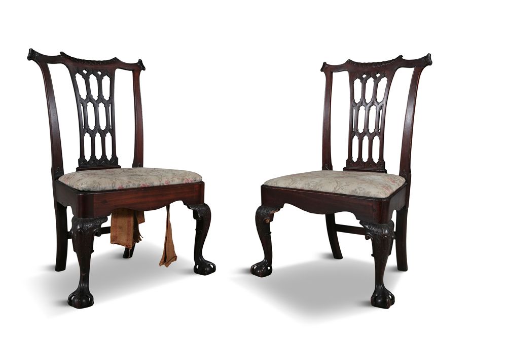 Null 一对爱尔兰桃花心木边椅，约1760年，雕刻有穿孔的哥特式椅背，圆角的落地式座椅，实心的异形围裙，平雕的凸形腿，有球和穿孔的脚。