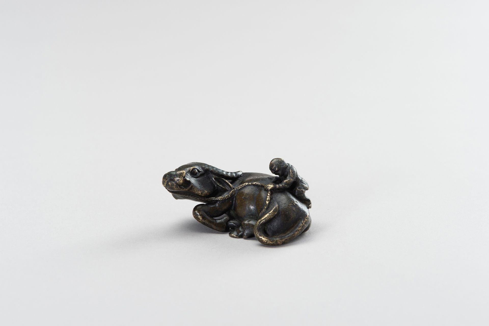 A FIGURAL BRONZE PAPERWEIGHT IN THE SHAPE OF A WATER BUFFALO AND HERDER PAPIERGE&hellip;