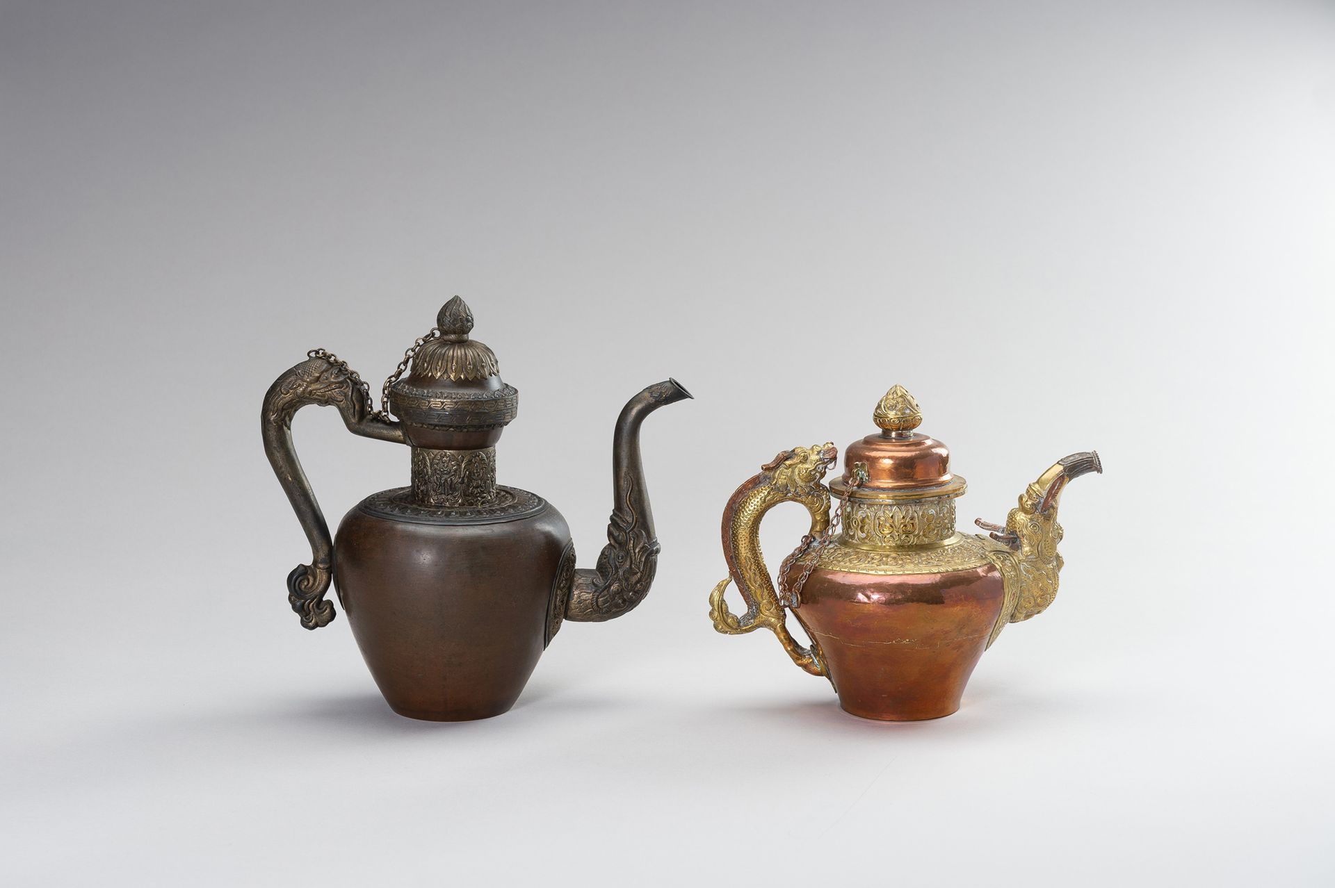 A PAIR OF TIBETAN COPPER REPOUSSÉ AND BRASS EWERS 一对西藏铜制复制品和铜制易拉罐
西藏，20世纪。第一件是铜制&hellip;