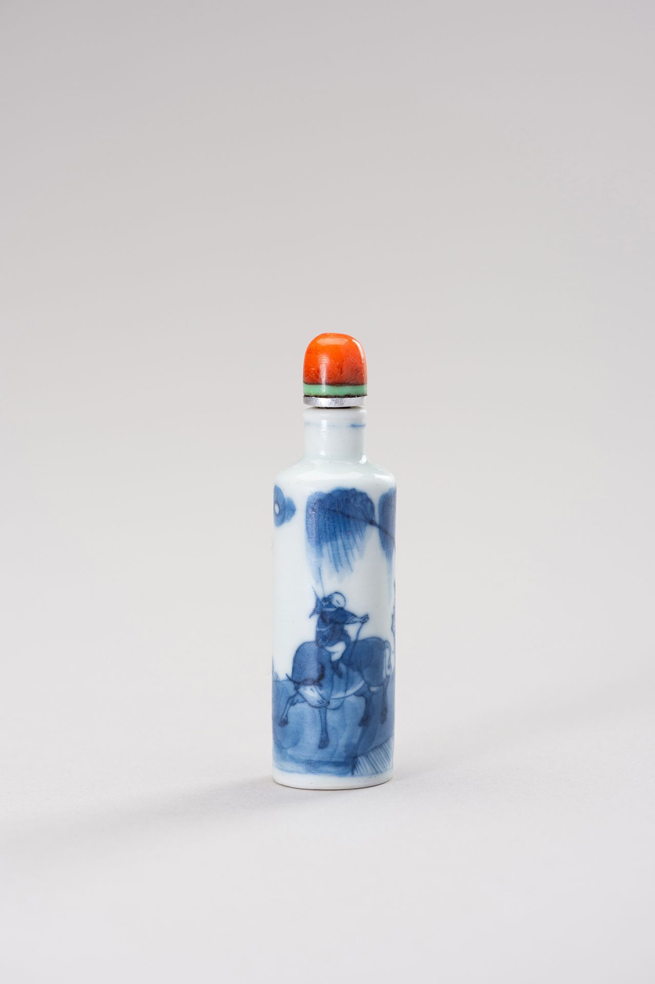 A BLUE AND WHITE PORCELAIN SNUFF BOTTLE 青花瓷鼻烟壶
中国，19世纪。圆柱形，釉下蓝装饰有松树下骑水牛的男孩。塞子是用红&hellip;