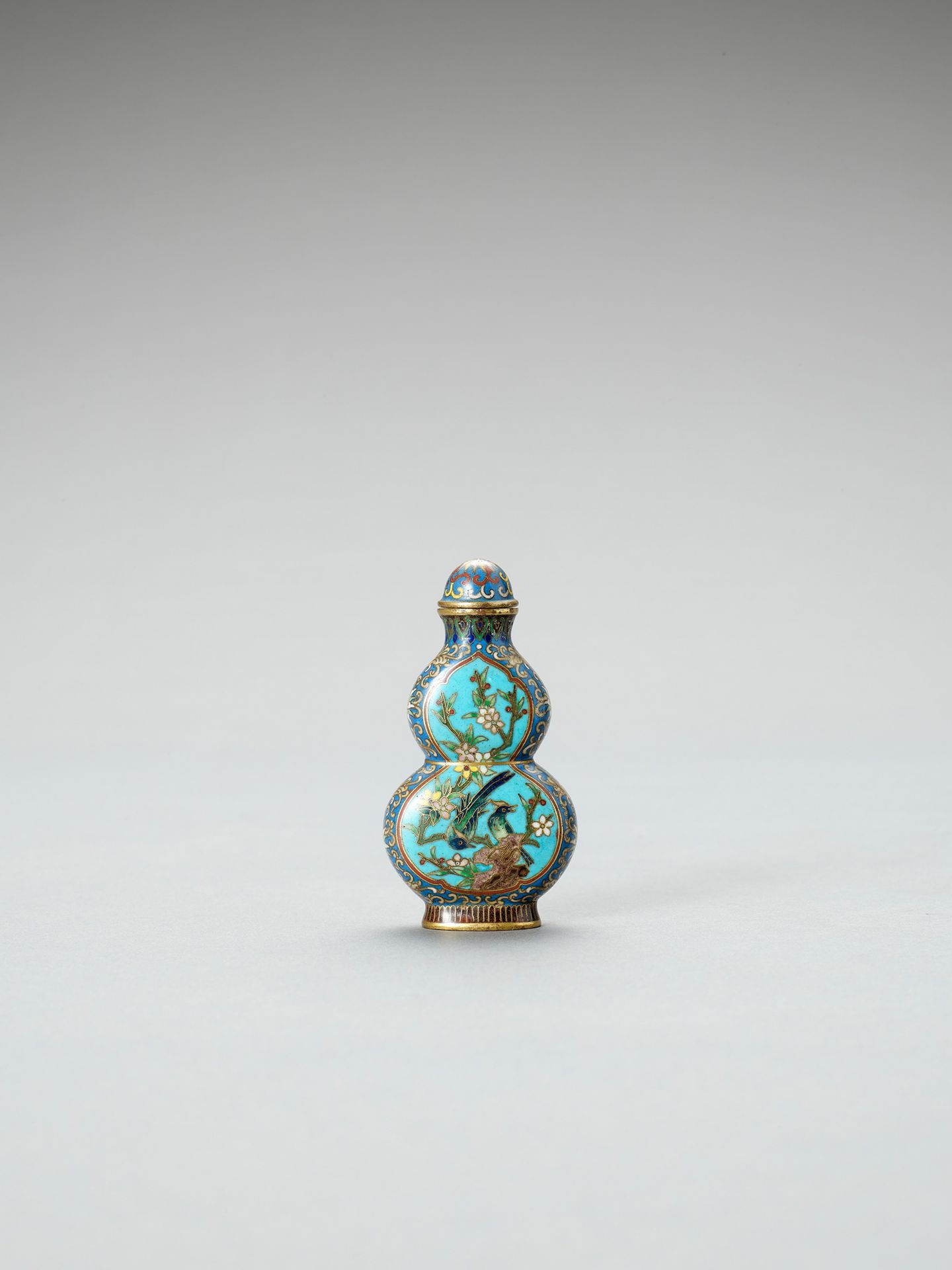 A DOUBLE-GOURD CLOISONNE SNUFF BOTTLE 一件双口克里奥森纳鼻烟壶
中国，19世纪末。瓶身装饰有两处储备，每一面都有鸟儿栖息在&hellip;